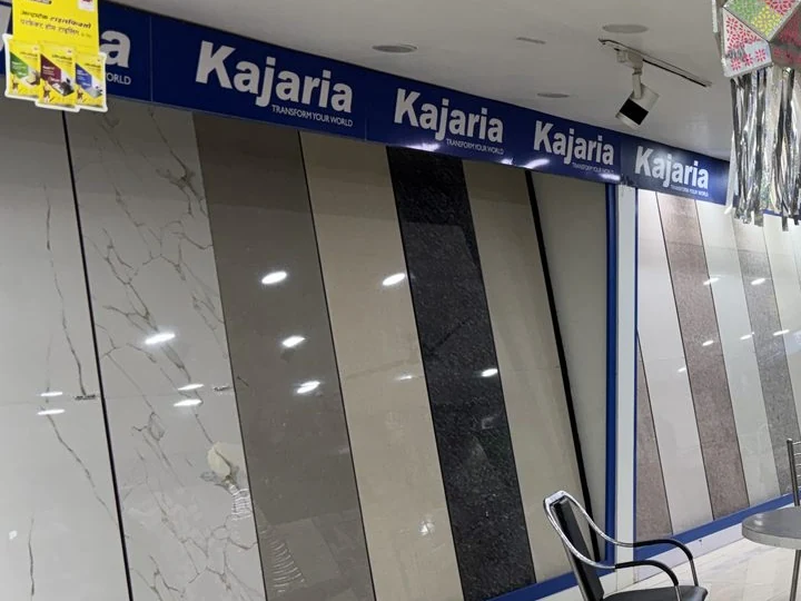 Balaji Mart, Bikapur में Kajaria display banner के नीचे Marble-finish और Stone-finish Tile panels