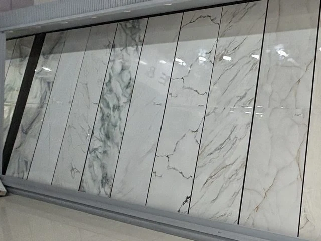 Large-format Tile wall पर हरी नसों वाली और सफ़ेद Marble-finish Tiles