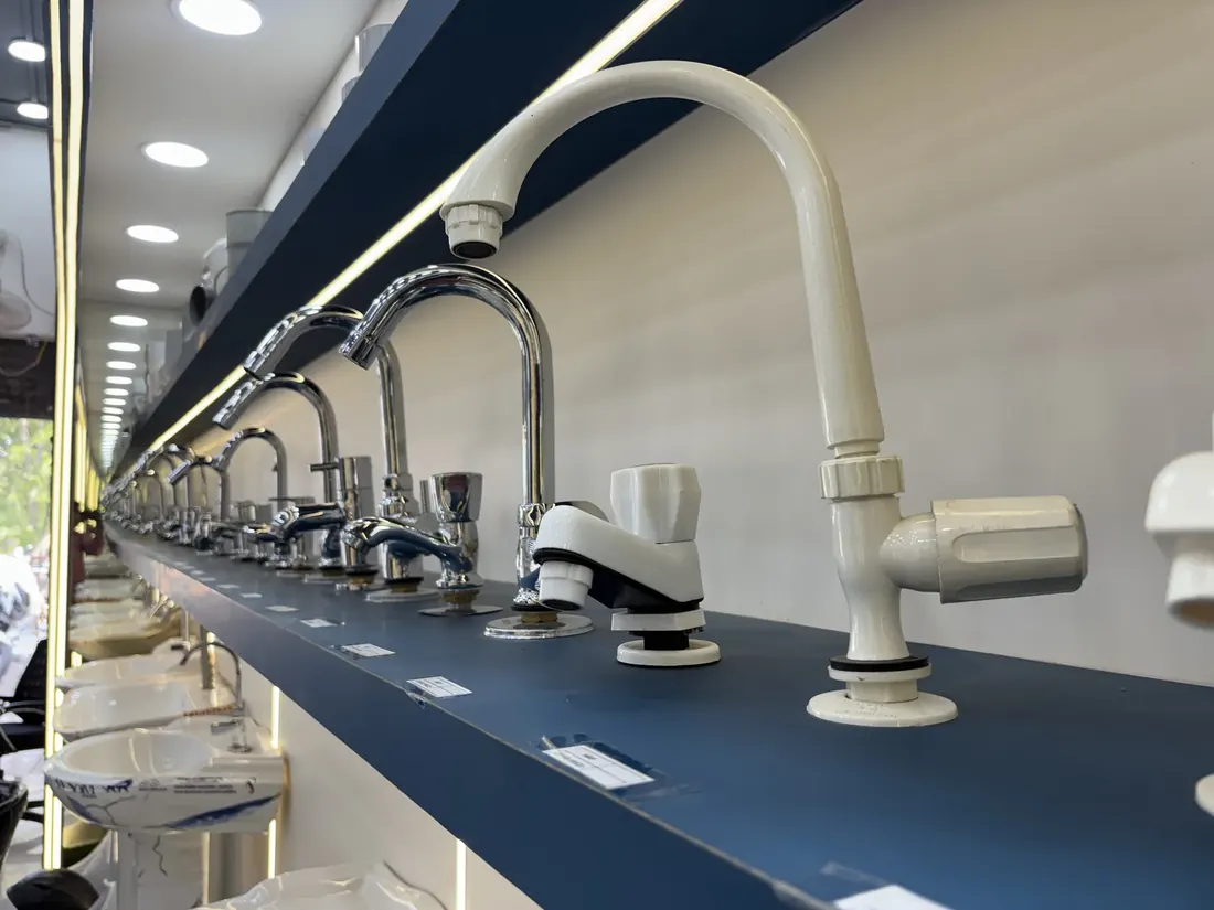 Swan neck taps for kitchen and basin displayed in rows at the Balaji Mart bathroom fittings counter, Bikapur